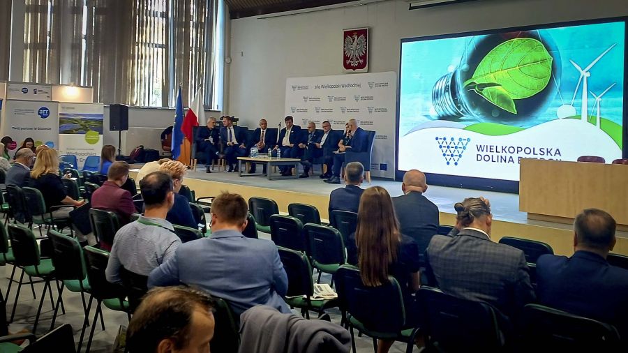 Siedząca publiczność obserwuje grupę dyskutujących