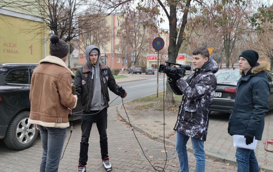 czwórka chłopców na chodniku z kamera i mikrofonem