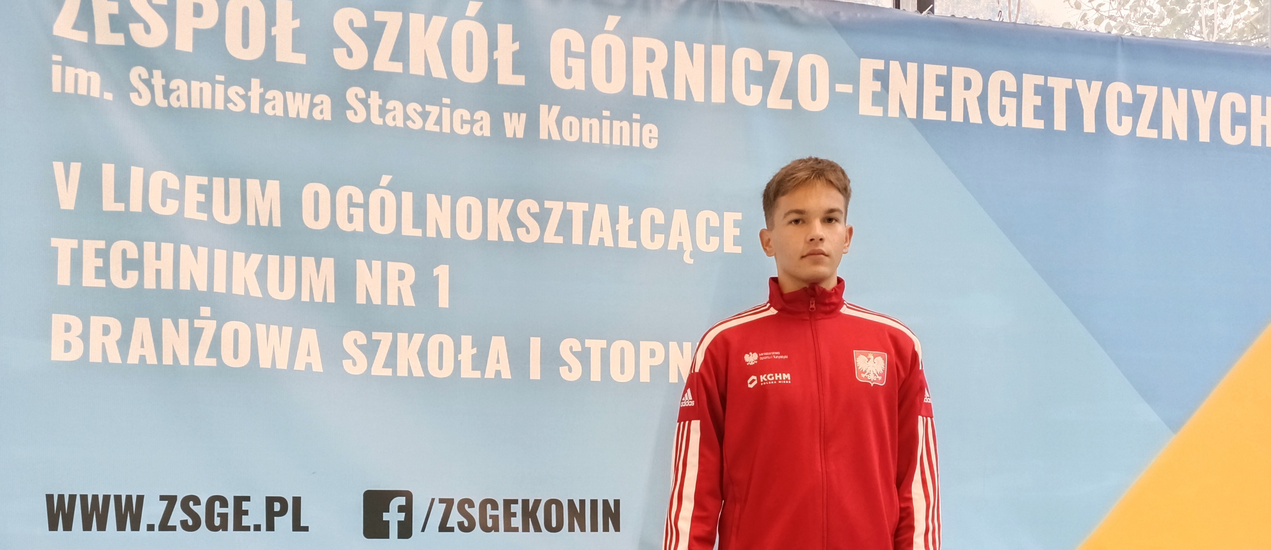 chłopak w czerwonym dresie z orzełkiem w tle baner reklamowy